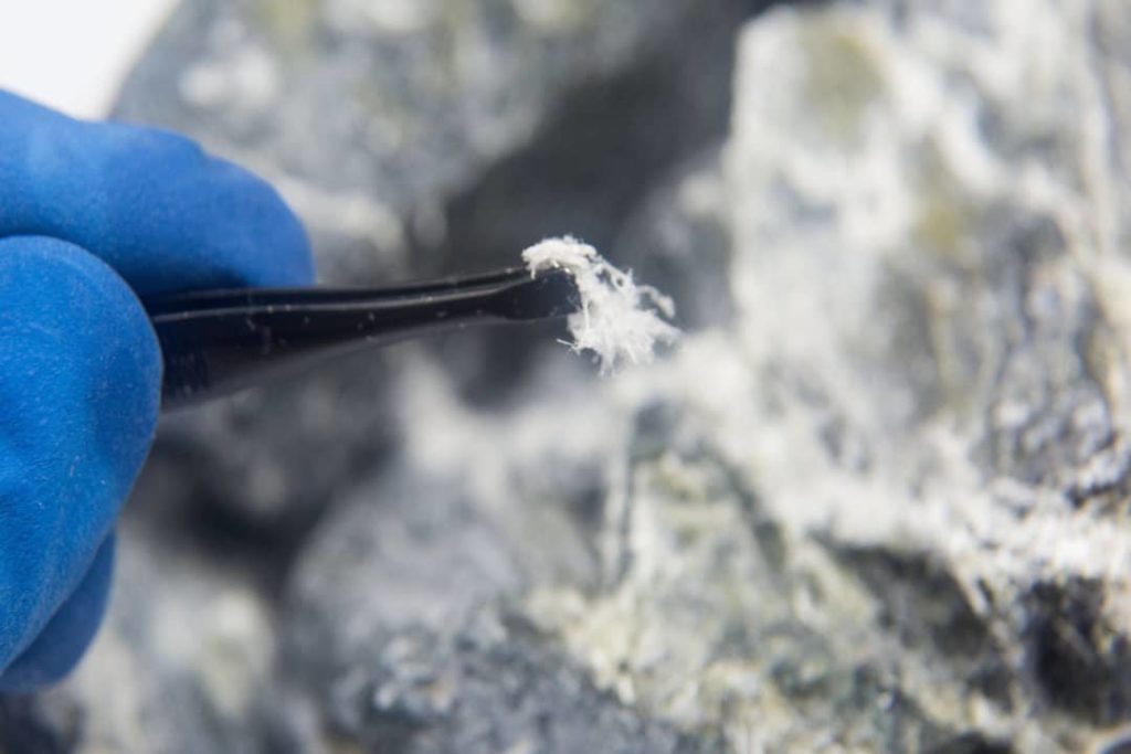 Épingle prélevant des fibres potentiellement amiantées sur un matériau